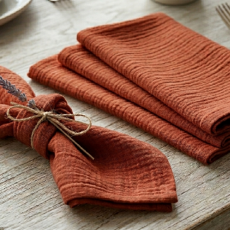 Location de serviette en gaze de coton terracotta texturée, couleur riche et profonde, pliage rustique avec lavande.