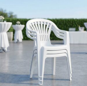 Pile de fauteuils de jardin blancs en plastique empilables disponibles à la location pour réceptions.